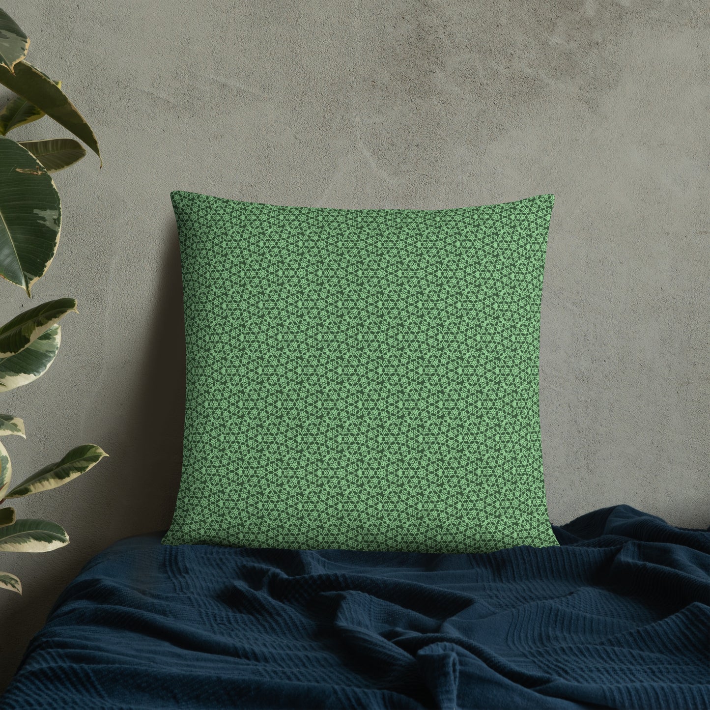 22″×22″ throw pillow with the 'Heptagon' green geometric pattern on a bed.