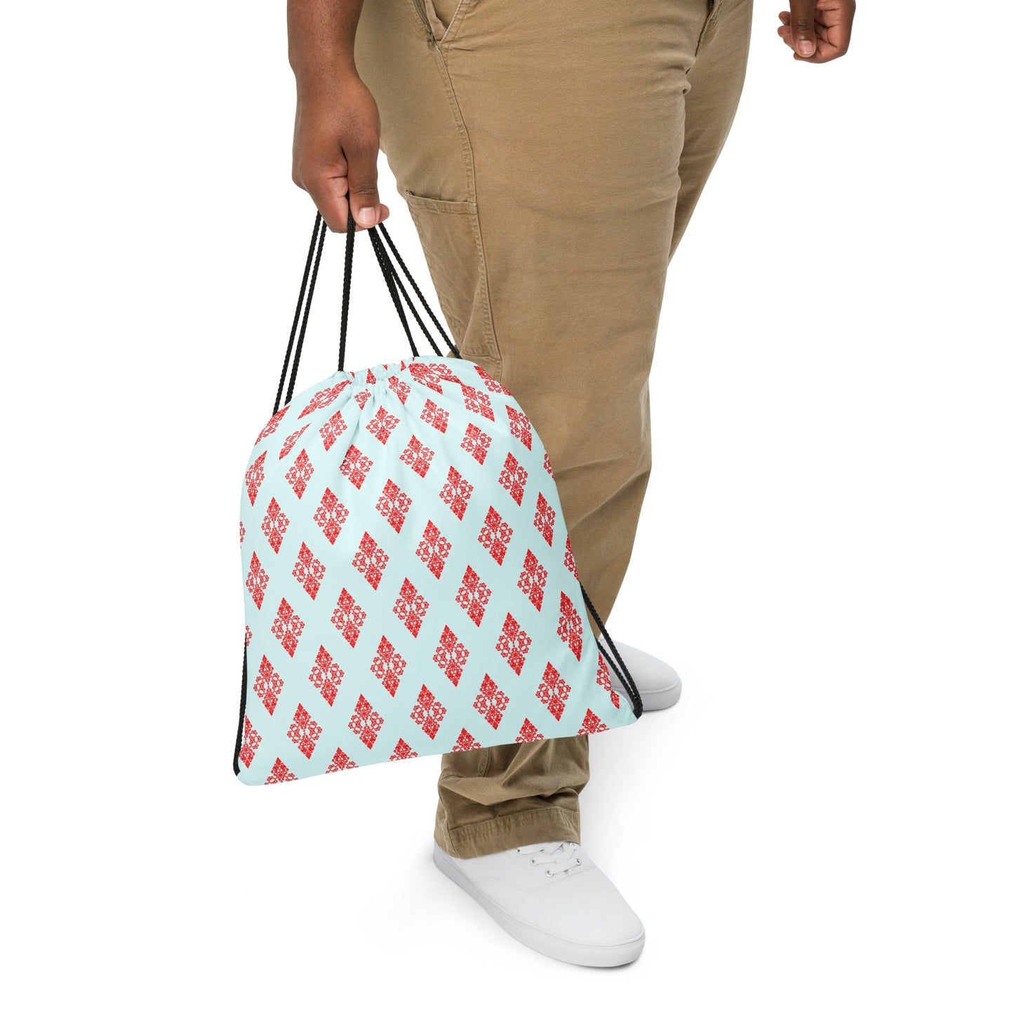 Close up of a person slinging the drawstring bag with the 'Digon' sky blue and red fractal geometric design.