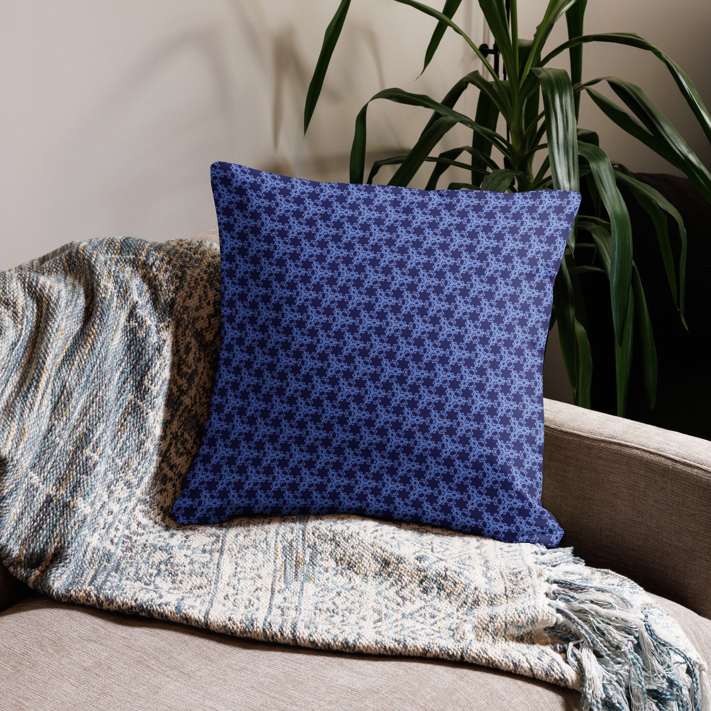 22″×22″ premium throw pillow with the 'Triagon' navy and blue geometric pattern on a couch.
