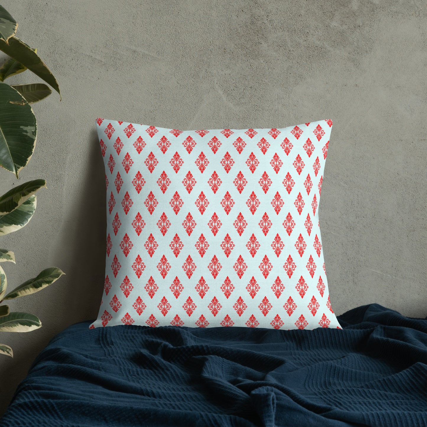 22″×22″ premium throw pillow with the 'Digon' sky blue and red geometric pattern on a bed.