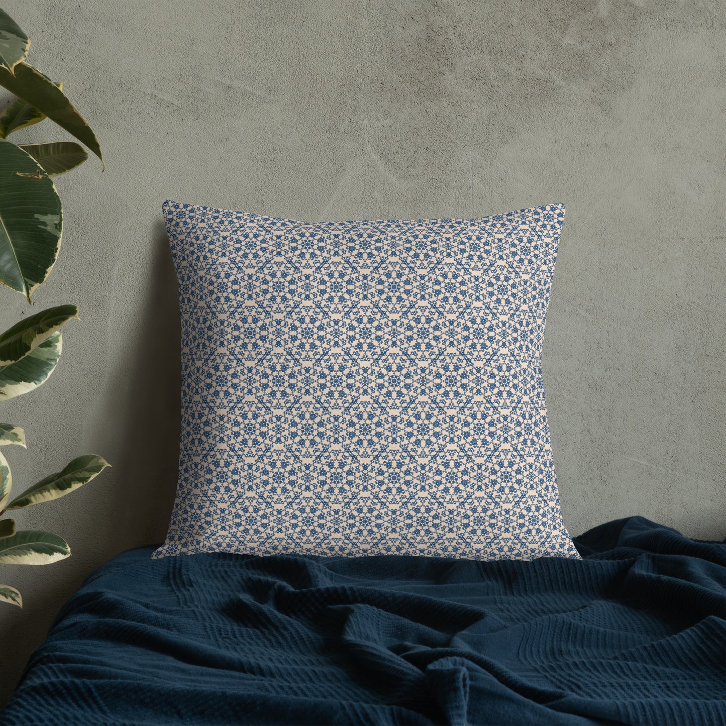 22″×22″ premium throw pillow with the ‘Octagon’ navy and beige geometric pattern on a bed with dark blanket.