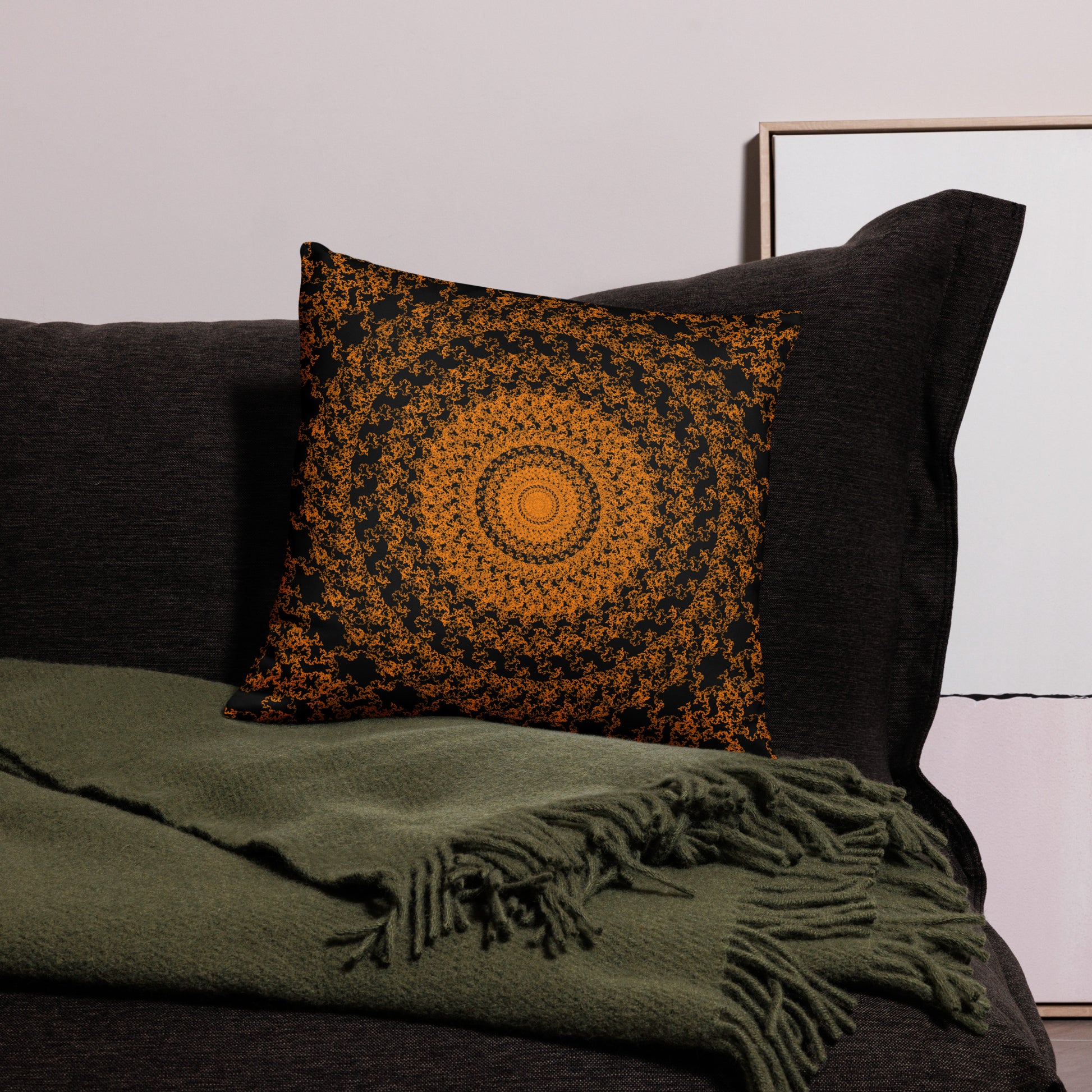 18″×18″ throw pillow with the 'The Sun' orange and black geometric design on a couch.
