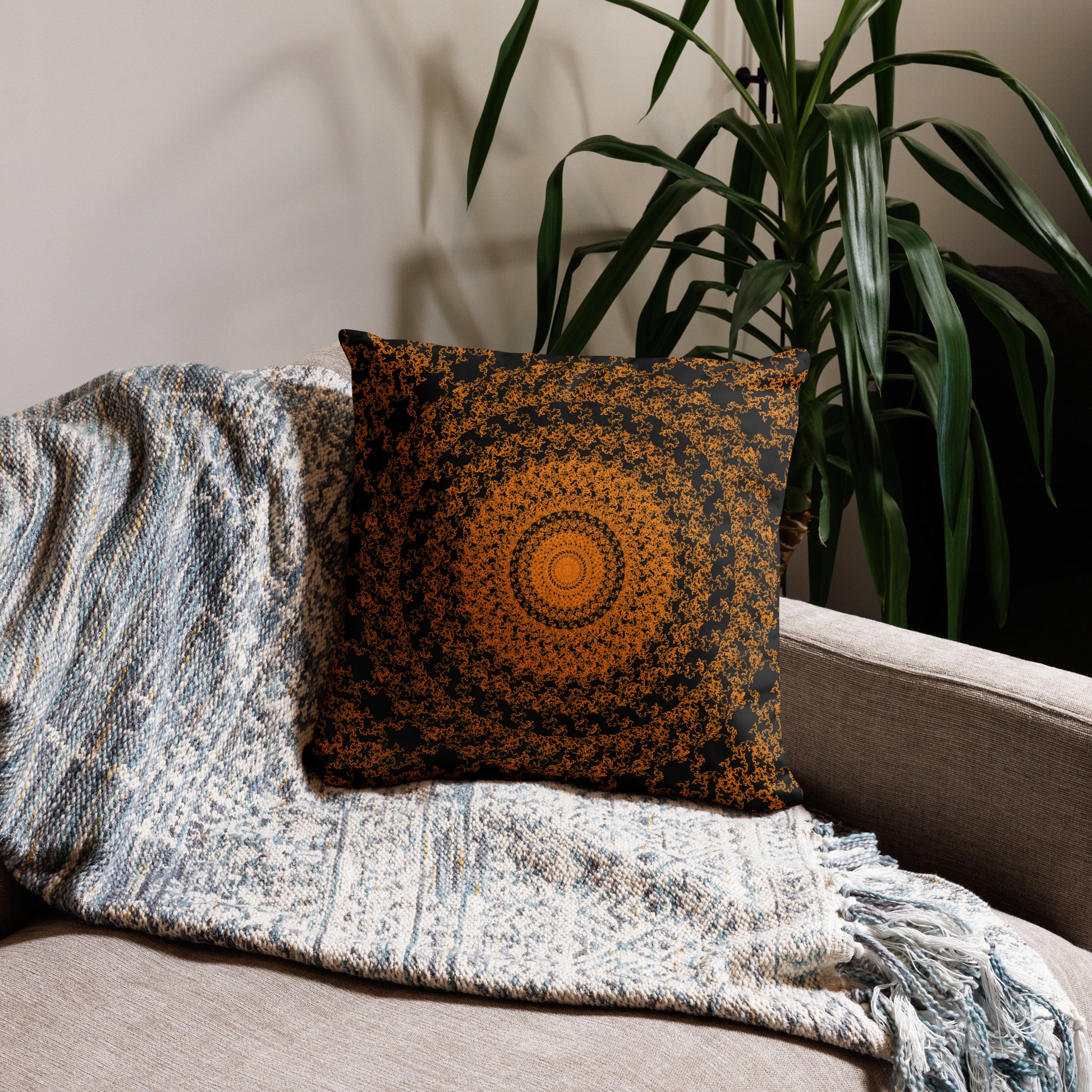 18″×18″ throw pillow with the 'The Sun' orange and black geometric design on a couch.