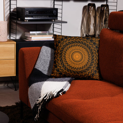 18″×18″ throw pillow with the 'The Sun' orange and black geometric design on a couch.