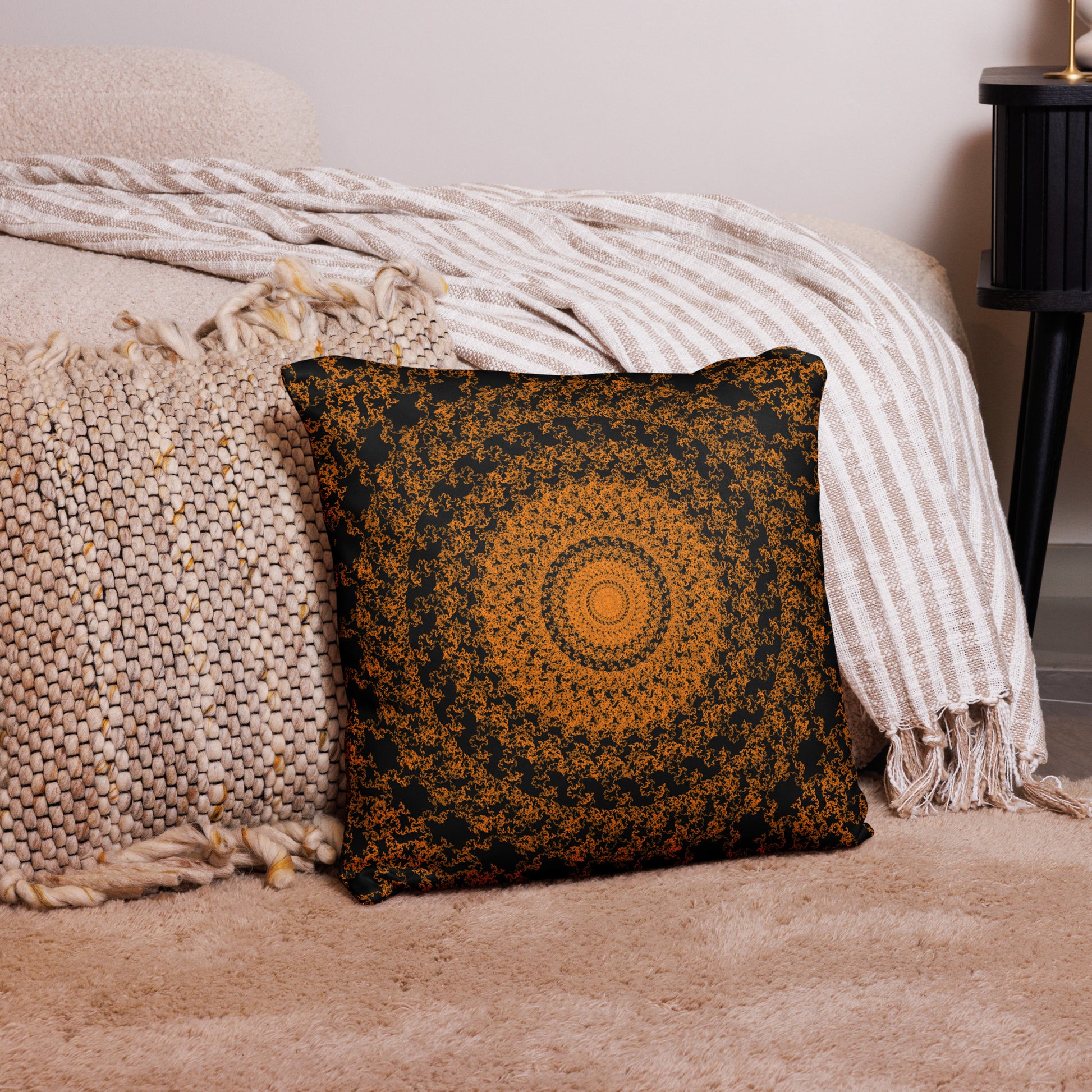 18″×18″ throw pillow with the 'The Sun' orange and black geometric design on a couch.