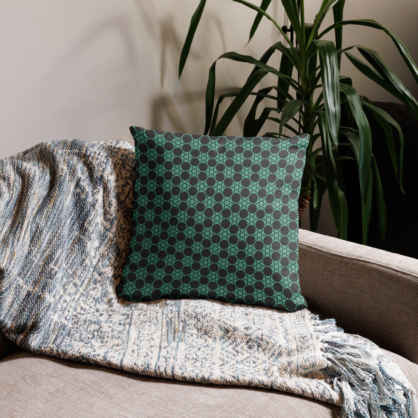 18″×18″ throw pillow with the 'Flowers Victory' charcoal and mint geometric pattern on a couch.