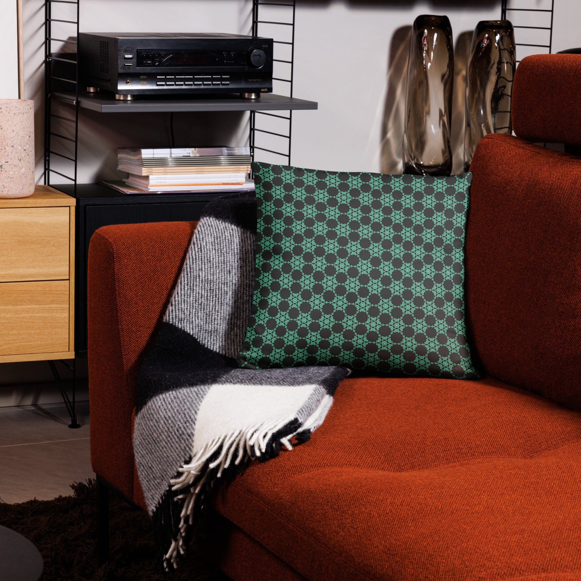 18″×18″ throw pillow with the 'Flowers Victory' charcoal and mint geometric pattern on a couch.