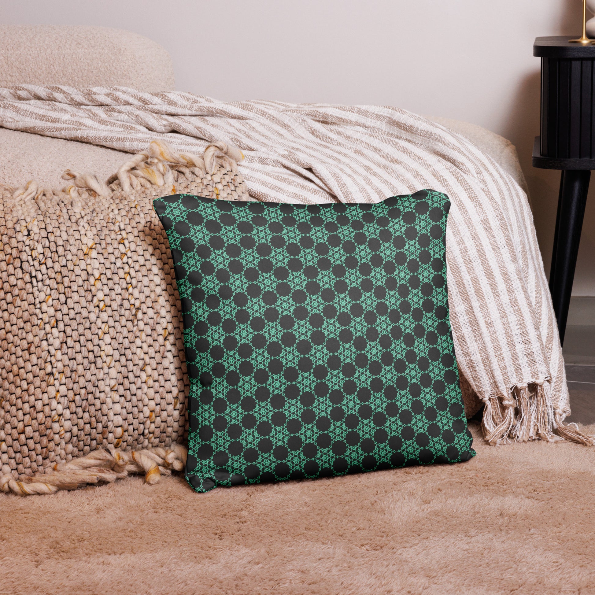 18″×18″ throw pillow with the 'Flowers Victory' charcoal and mint geometric pattern on a couch.