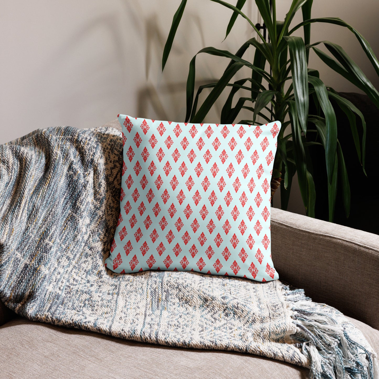 18″×18″ throw pillow with the 'Digon' sky blue and red geometric pattern on a couch.