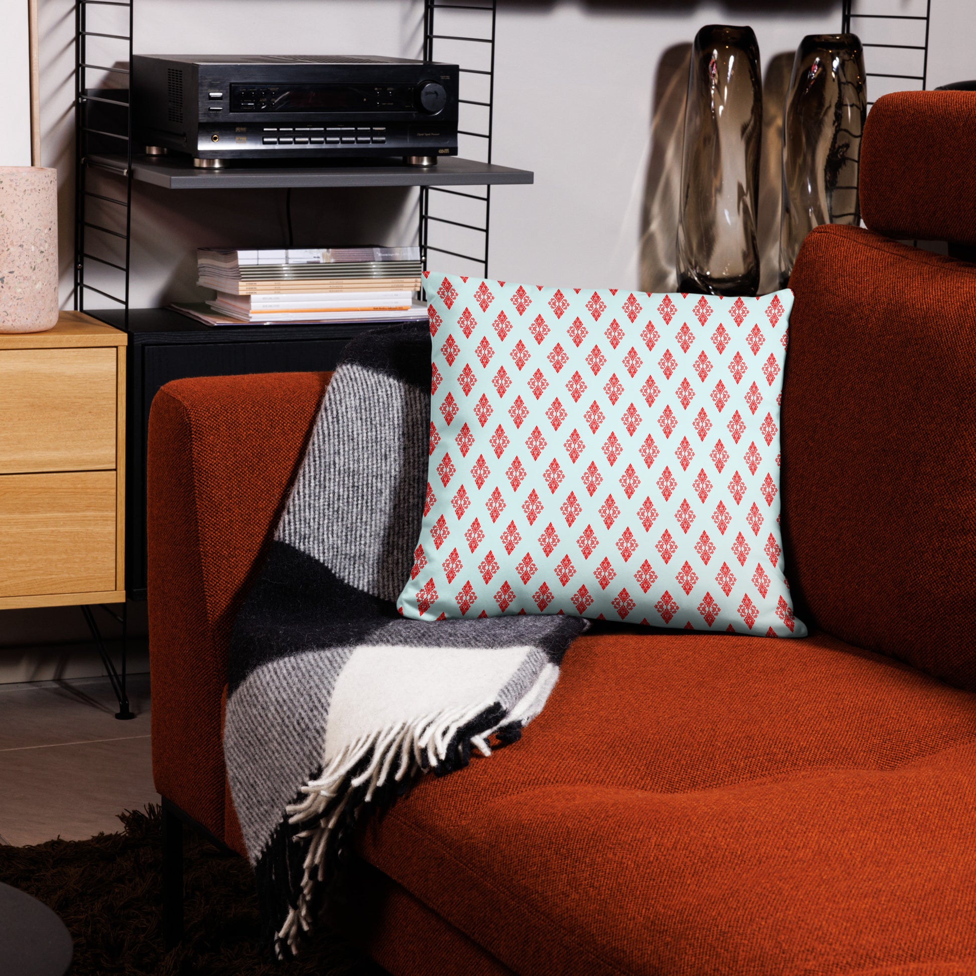 18″×18″ throw pillow with the 'Digon' sky blue and red geometric pattern on a couch.