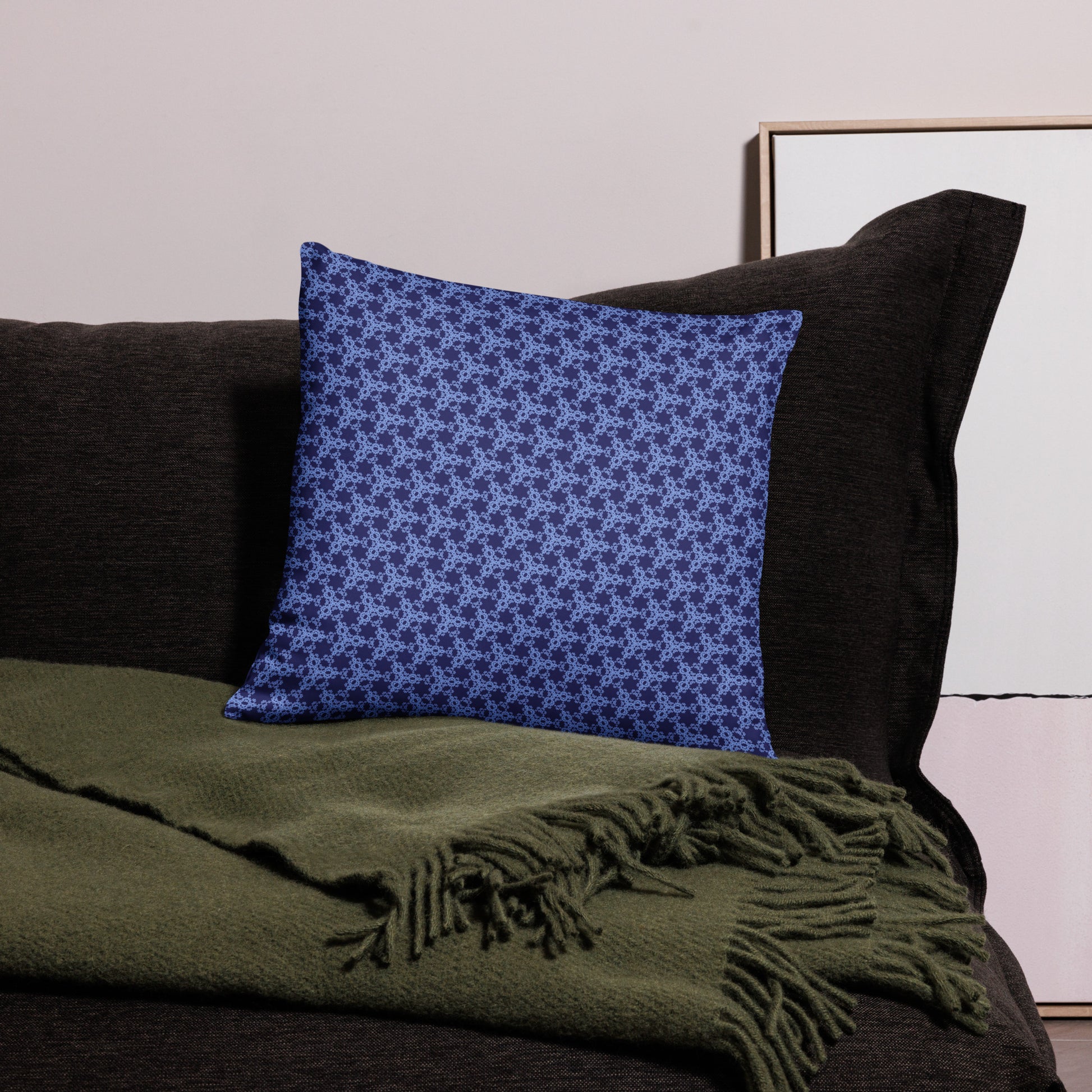 18″×18″ throw pillow with the 'Trigon' navy and blue geometric pattern on a couch.