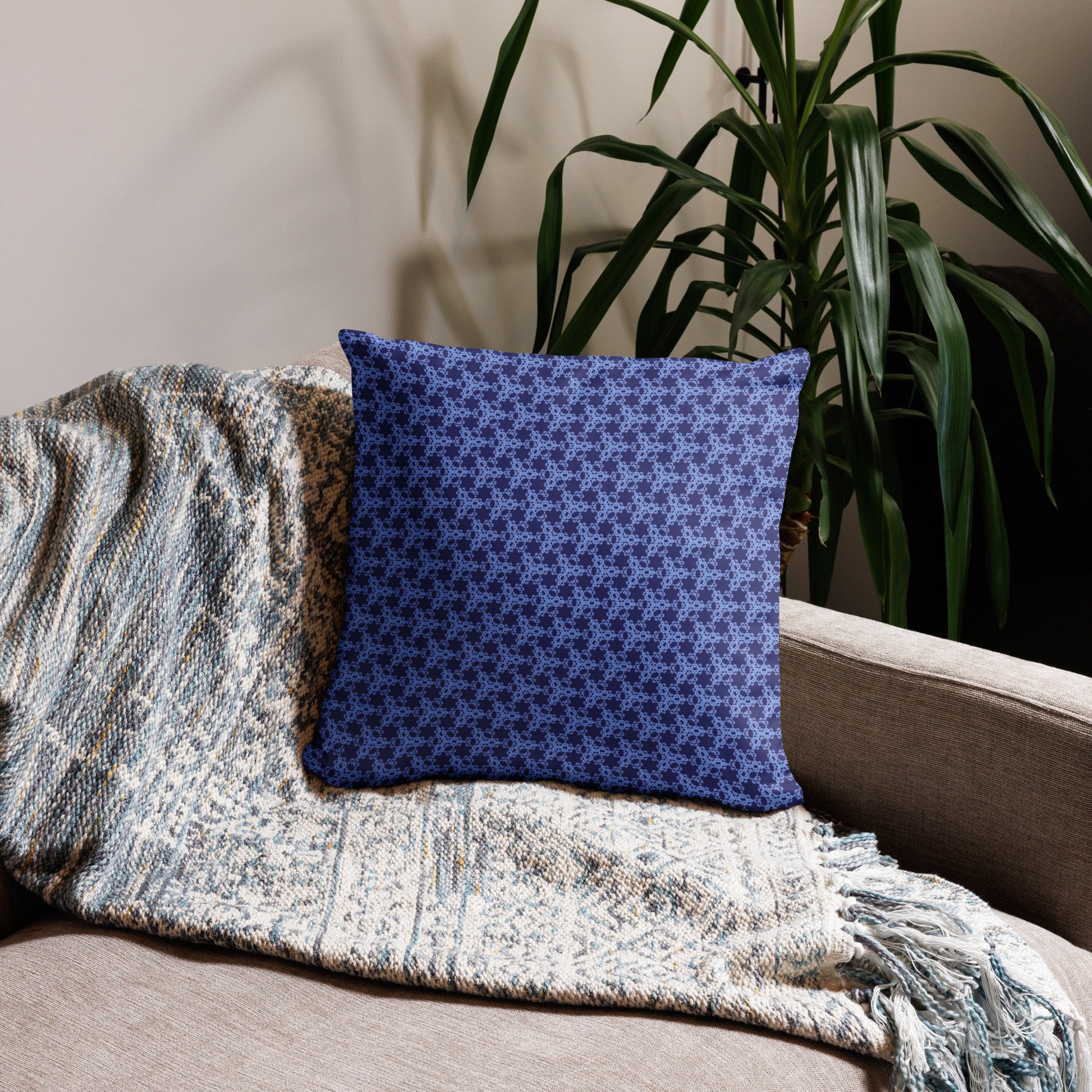 18″×18″ throw pillow with the 'Trigon' navy and blue geometric pattern on a couch.