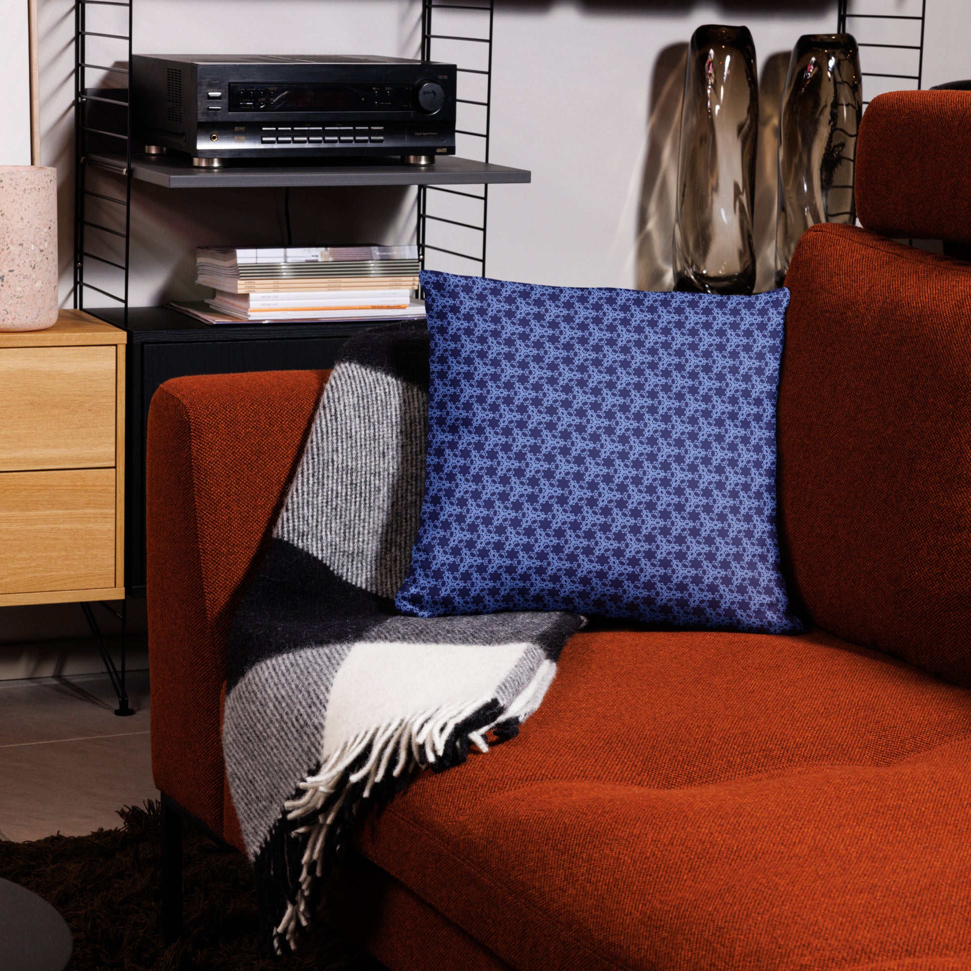 18″×18″ throw pillow with the 'Trigon' navy and blue geometric pattern on a couch.