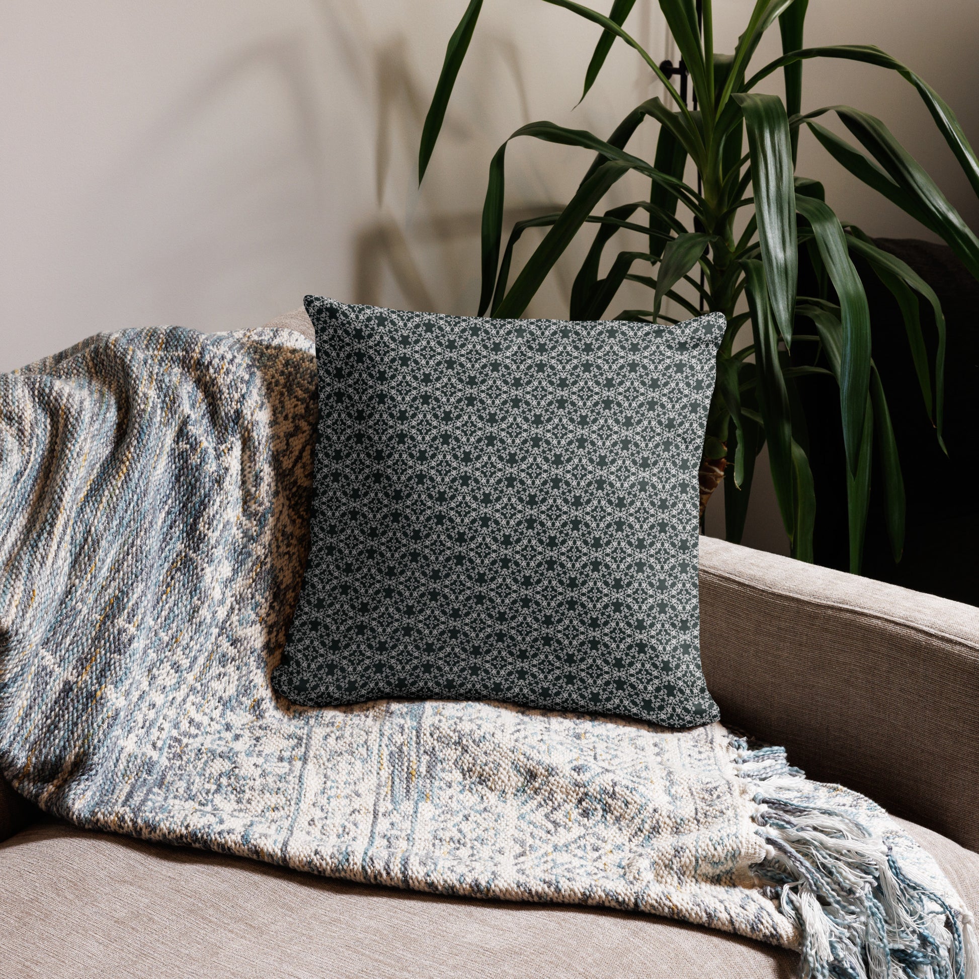 18″×18″ throw pillow with the 'Tetragon' charcoal and white geometric pattern on a couch.