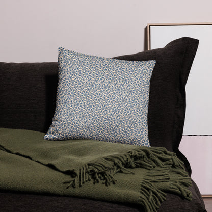 18″×18″ throw pillow with the ‘Octagon’ navy and beige geometric pattern on a dark sofa with throw blanket.