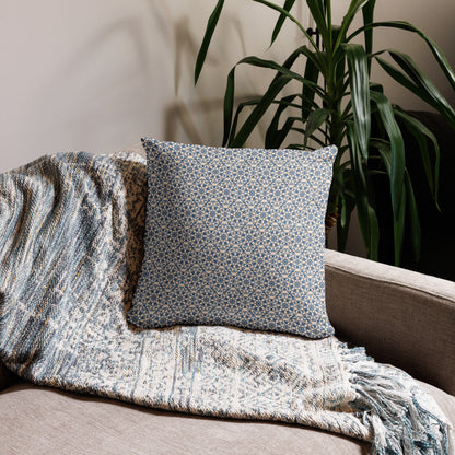 18″×18″ throw pillow with the ‘Octagon’ navy and beige geometric pattern on a sofa with fringed blanket.