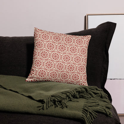 18″×18″ throw pillow with the ‘Decagon’ terracotta and beige geometric pattern on a black sofa with an olive throw.