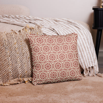 18″×18″ throw pillow with the ‘Decagon’ terracotta and beige geometric pattern on a bedroom floor with striped linen throws.