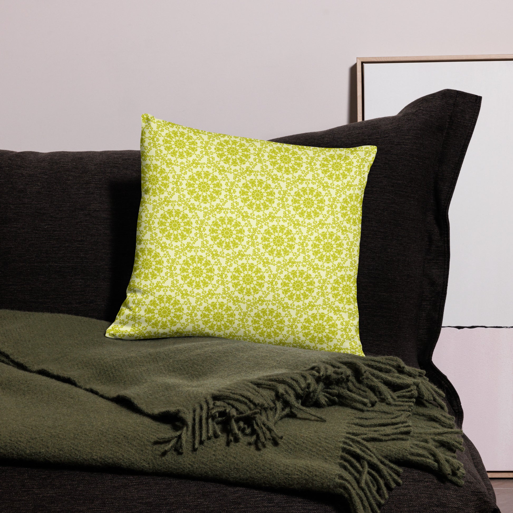 18″×18″ throw pillow with the 'Hendecagon' yellow-green geometric pattern on a dark sofa with green throw
