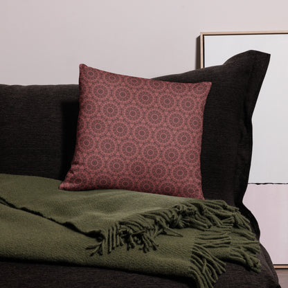 18″×18″ throw pillow with the 'Dodecagon' rose geometric pattern on dark sofa with green fringed throw.