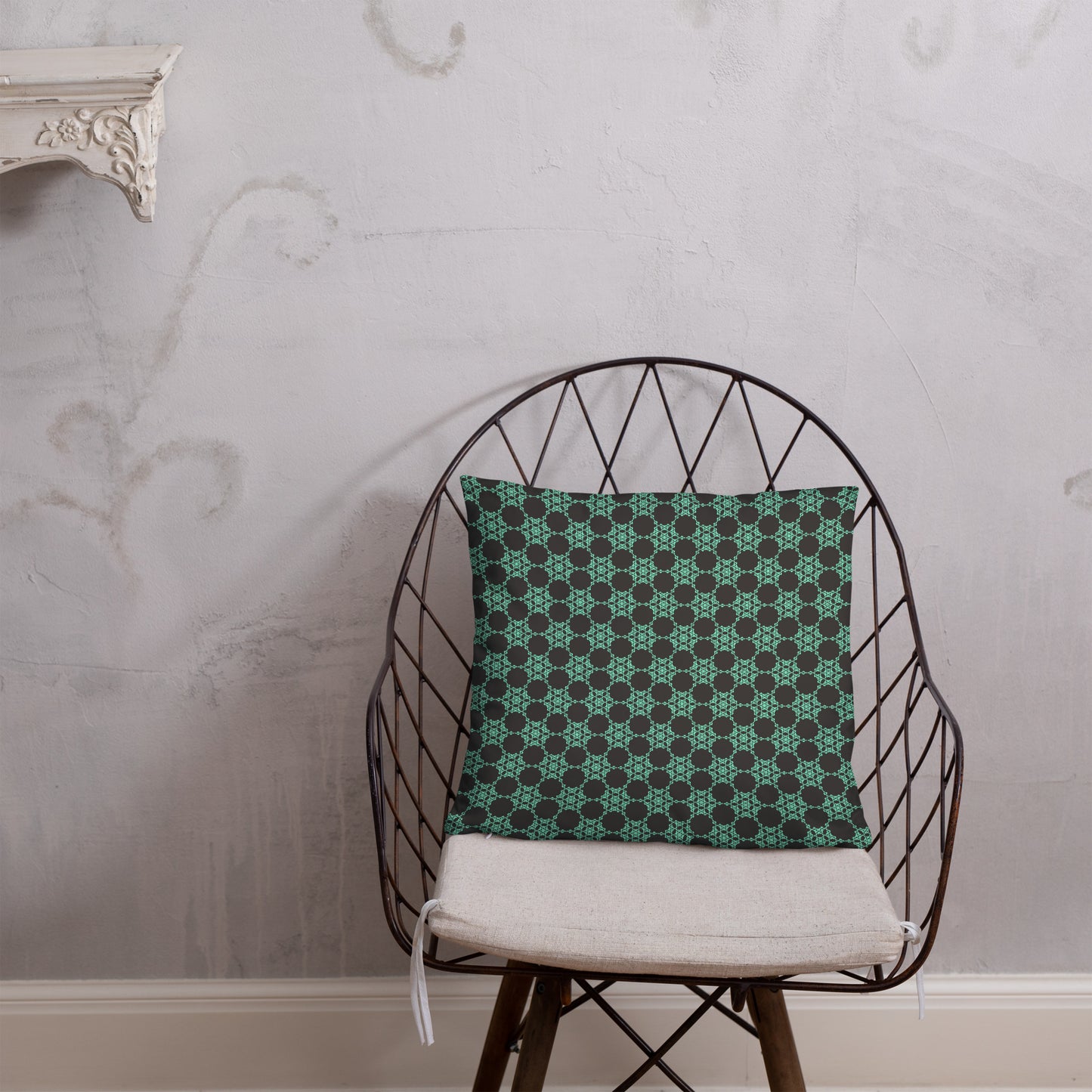 18″×18″ throw pillow with the 'Flowers Victory' charcoal and mint geometric pattern on a chair.