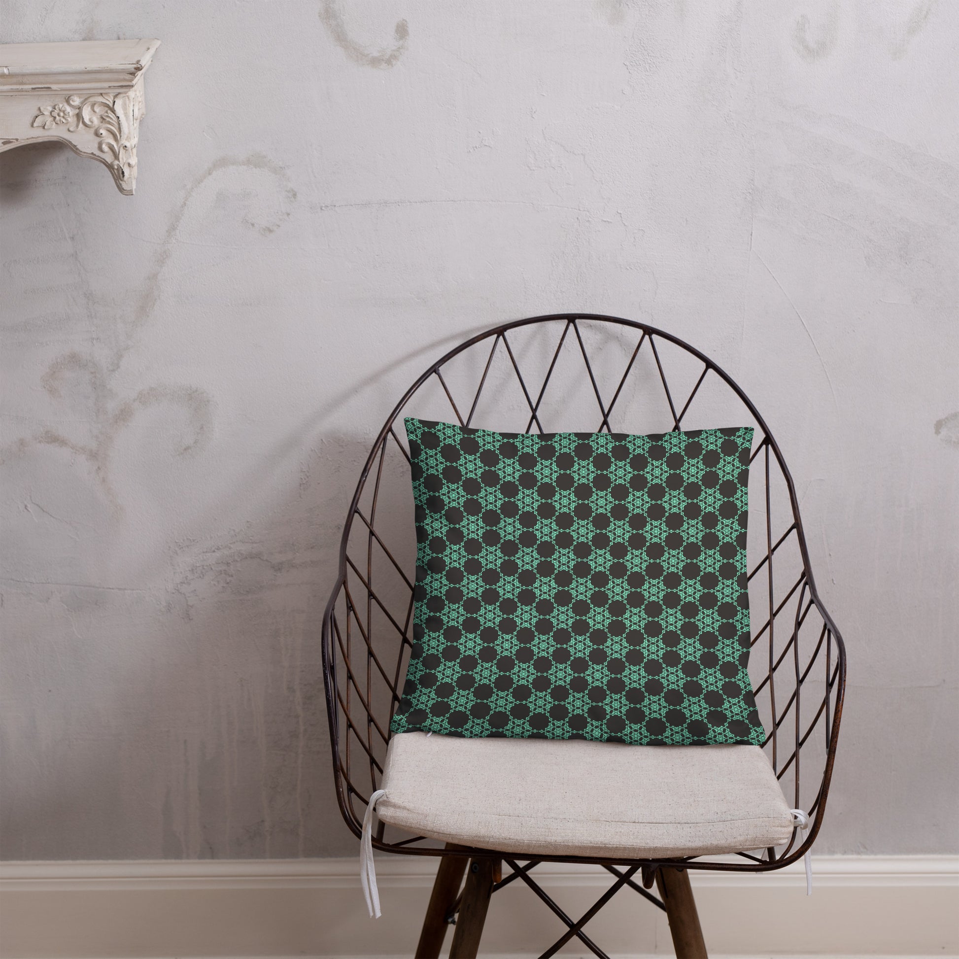 18″×18″ throw pillow with the 'Flowers Victory' charcoal and mint geometric pattern on a chair.
