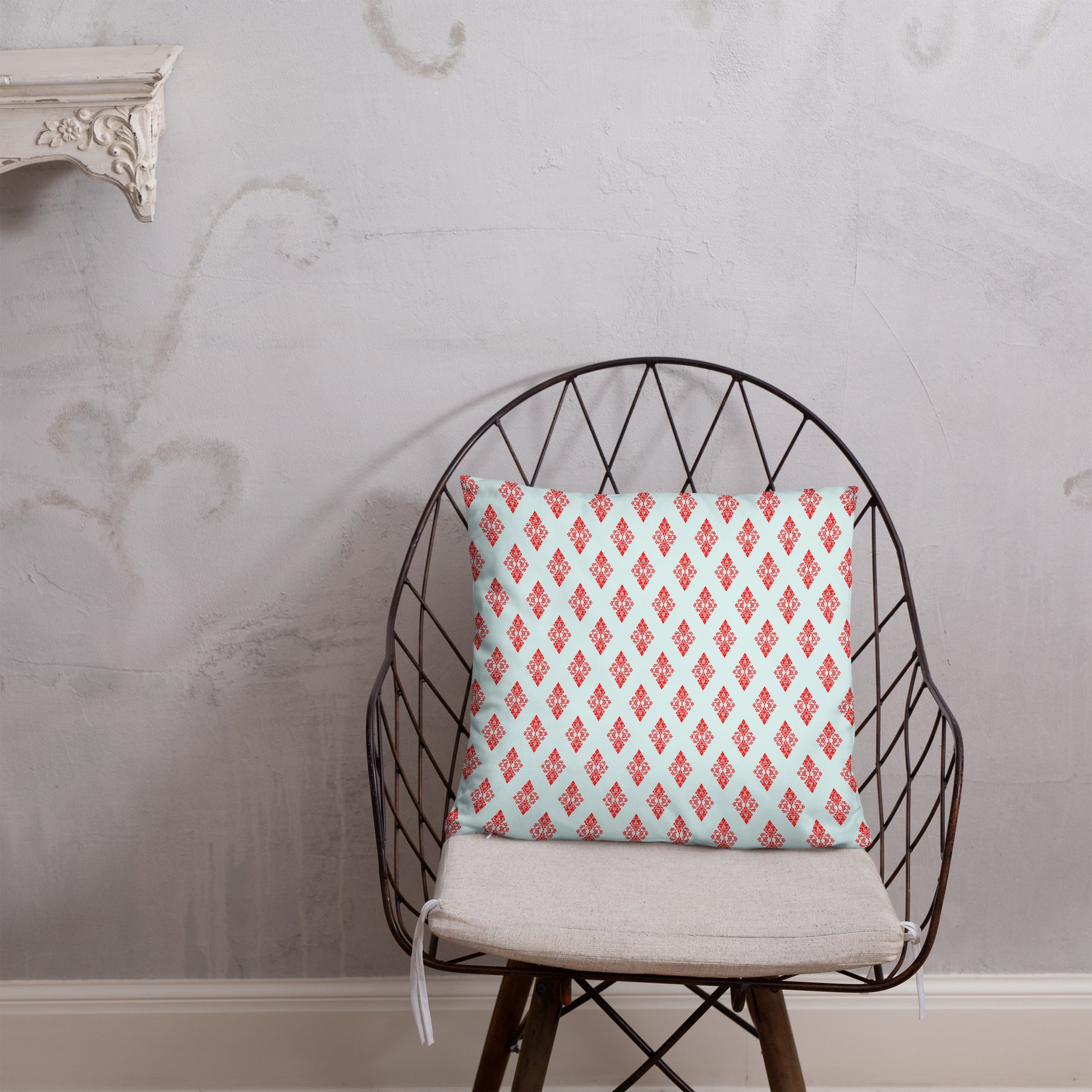18″×18″ throw pillow with the 'Digon' sky blue and red geometric pattern on a chair.