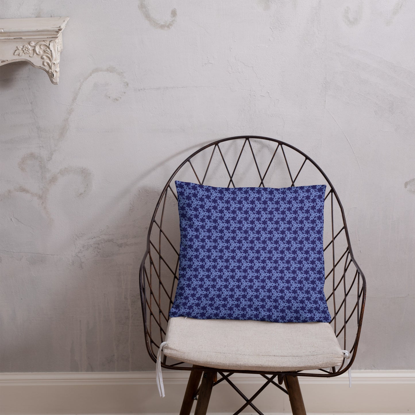 18″×18″ throw pillow with the 'Trigon' navy and blue geometric pattern on a chair.