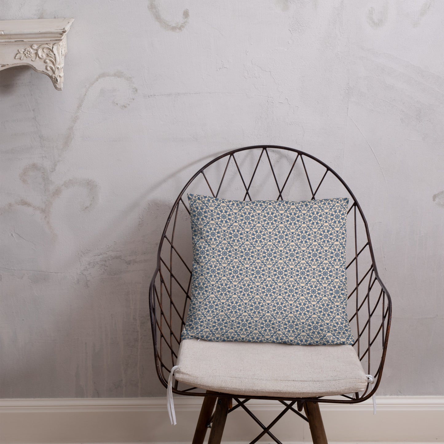 18″×18″ throw pillow with the ‘Octagon’ navy and beige geometric pattern on a wire chair.