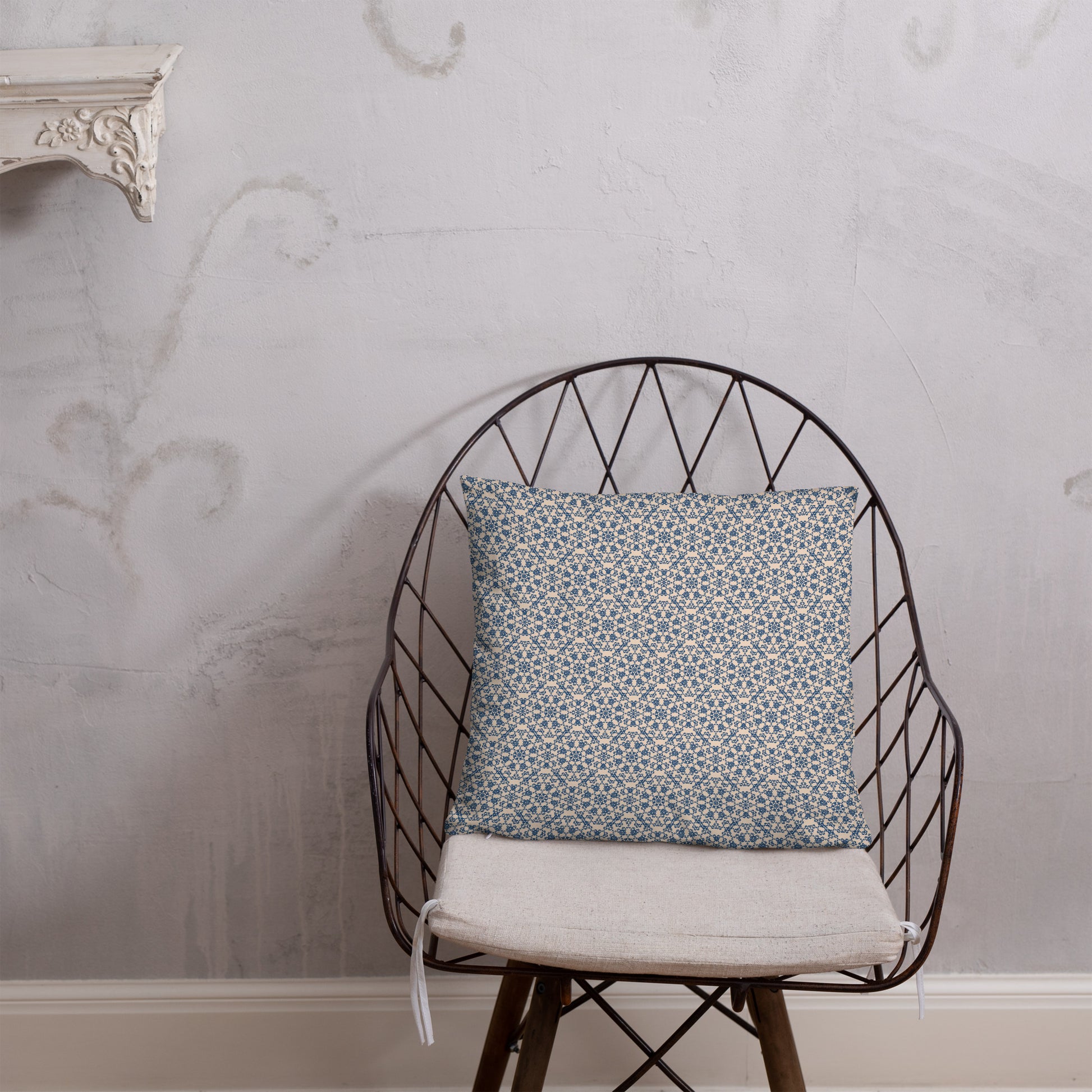18″×18″ throw pillow with the ‘Octagon’ navy and beige geometric pattern on a wire chair.