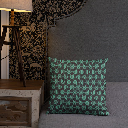 18″×18″ throw pillow with the 'Flowers Victory' charcoal and mint geometric pattern on a bed.