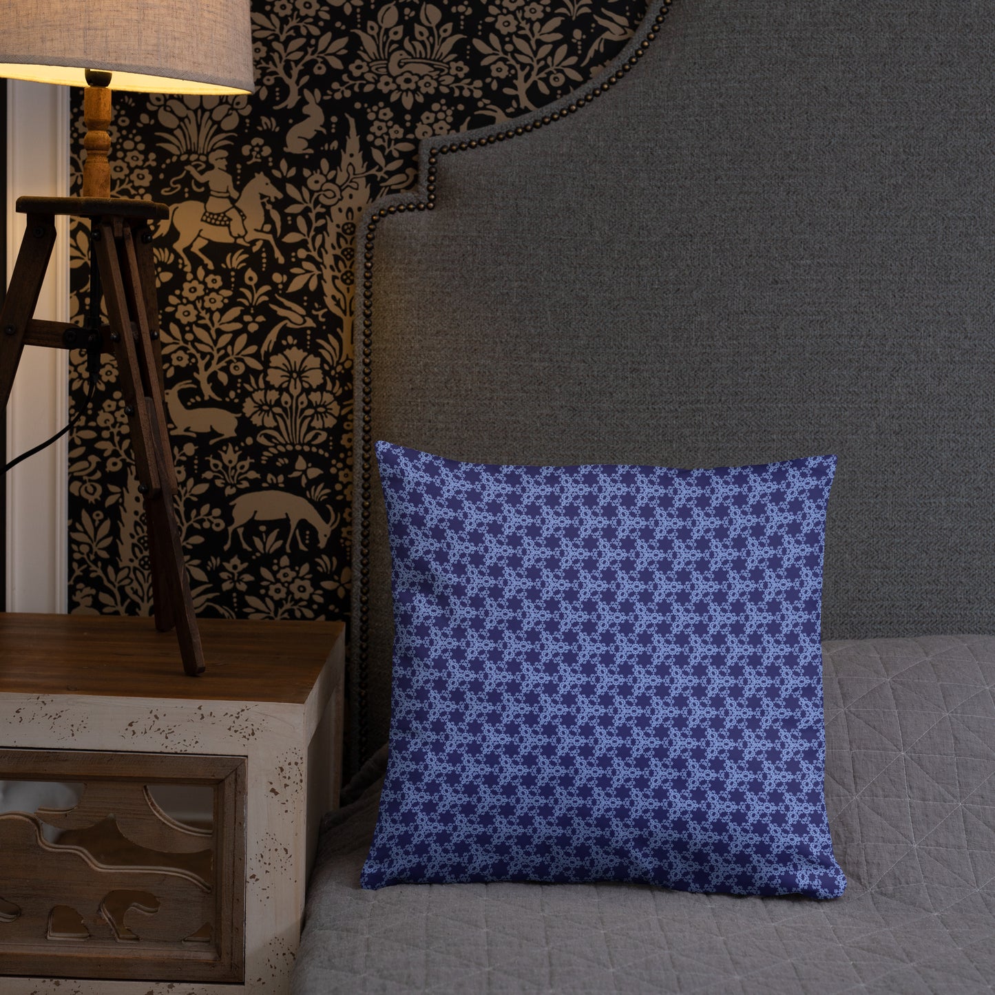 18″×18″ throw pillow with the 'Trigon' navy and blue geometric pattern on a bed.