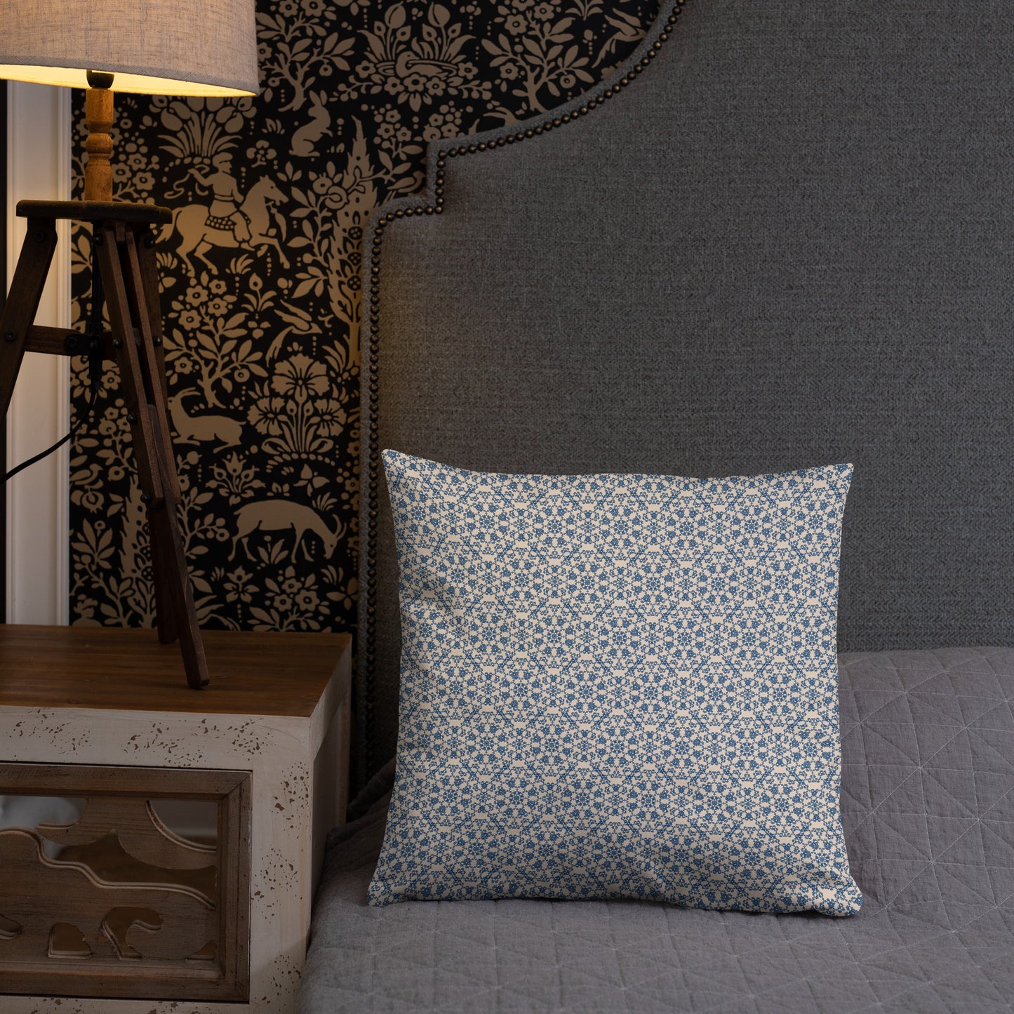 18″×18″ throw pillow with the ‘Octagon’ navy and beige geometric pattern on a bed with upholstered headboard.