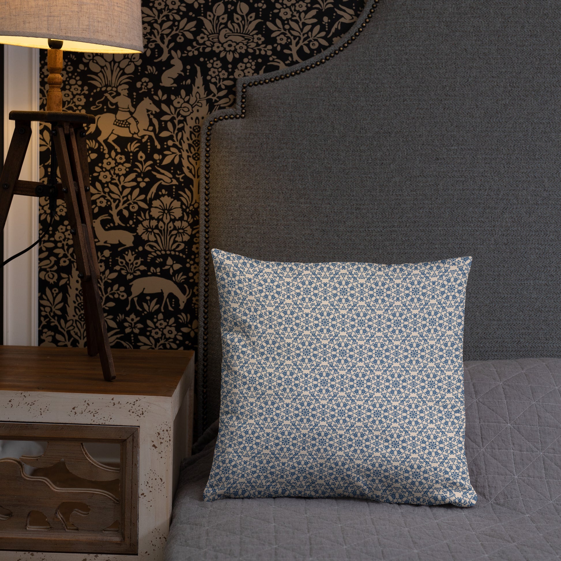 18″×18″ throw pillow with the ‘Octagon’ navy and beige geometric pattern on a bed with upholstered headboard.