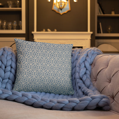 18″×18″ throw pillow with the ‘Octagon’ navy and beige geometric pattern on a sofa with chunky knit blanket.