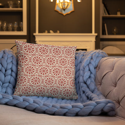 18″×18″ throw pillow with the ‘Decagon’ terracotta and beige geometric pattern on a blue sofa with a chunky knit blanket.