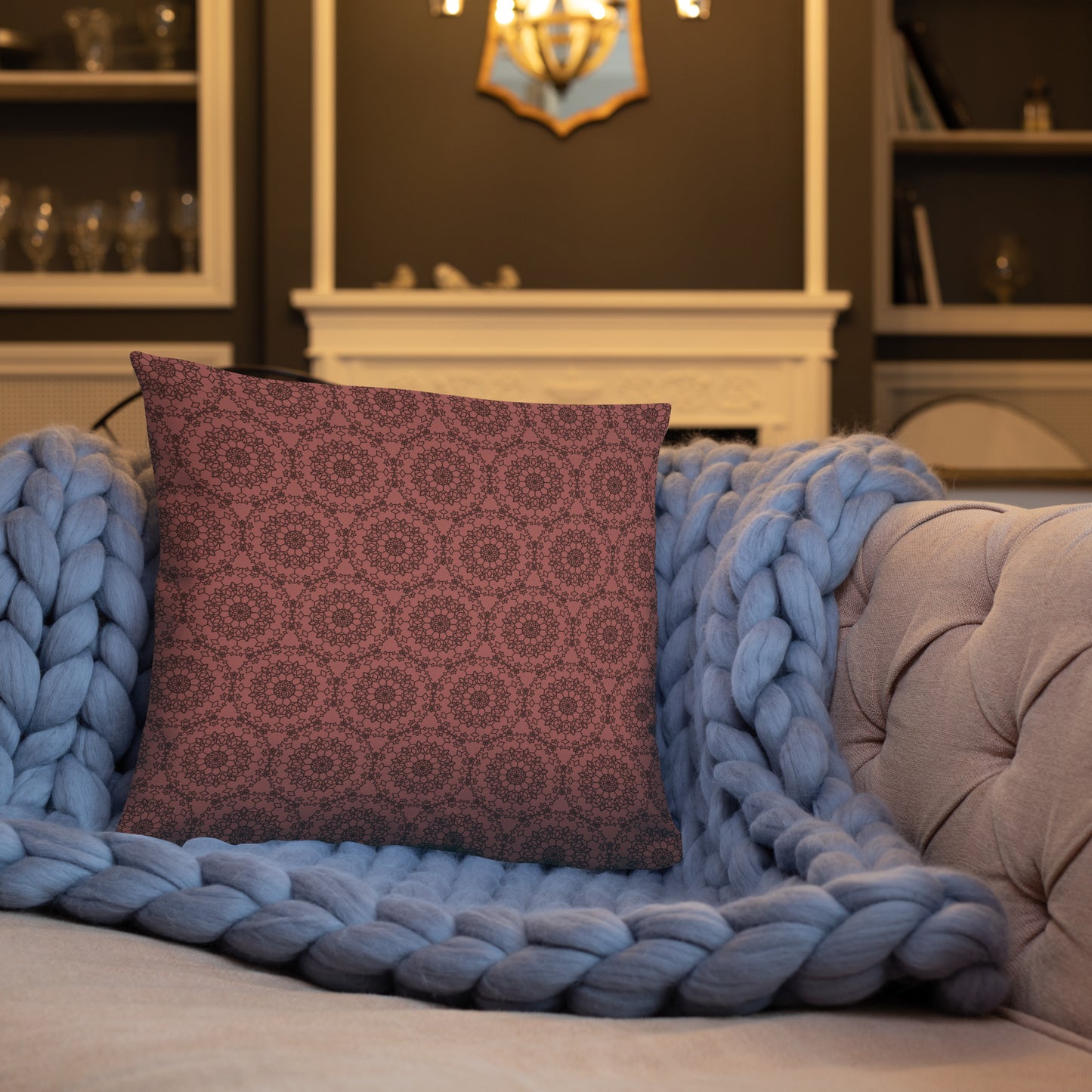 18″×18″ throw pillow with the 'Dodecagon' rose geometric pattern on tufted sofa with chunky blue knit blanket.