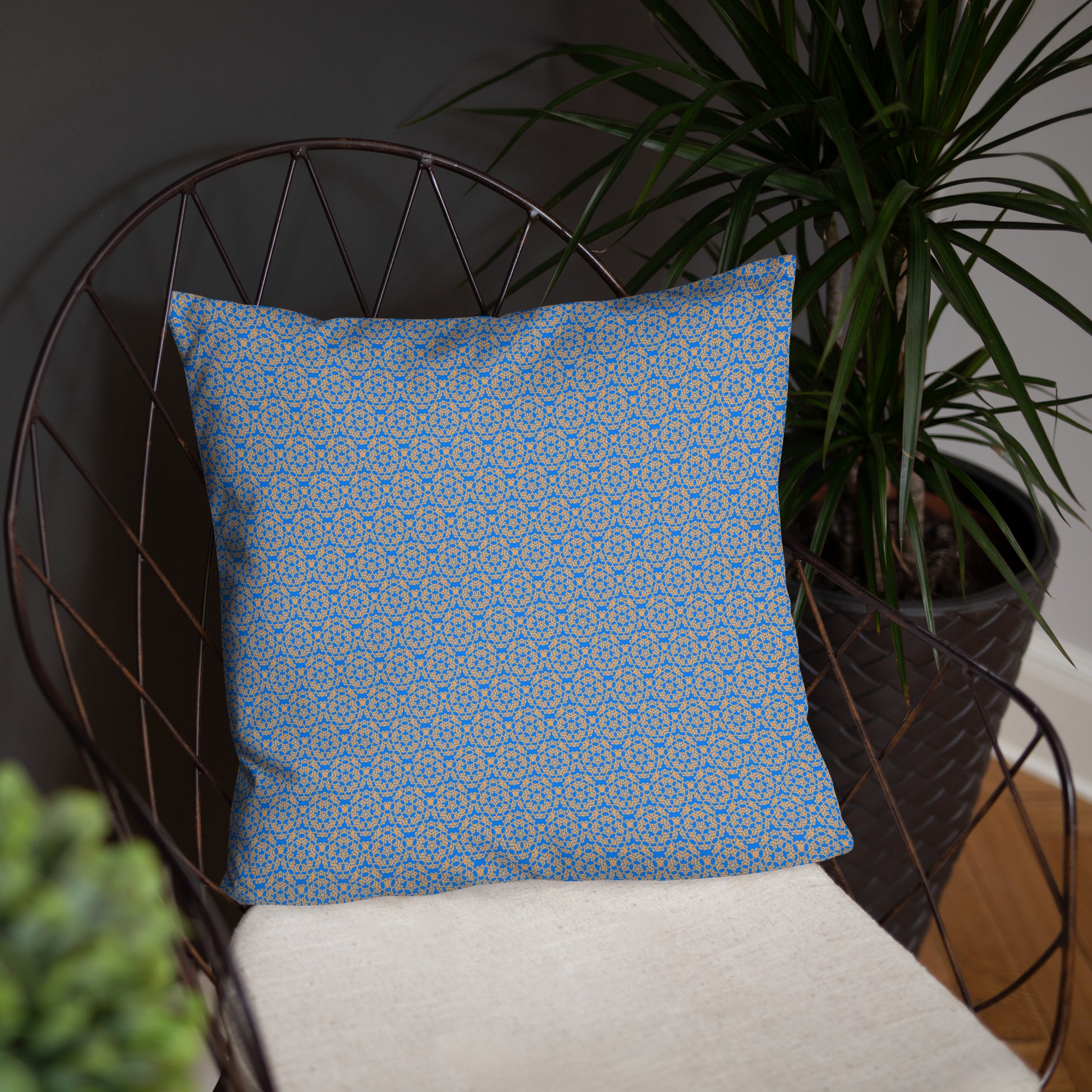 Front of the 18″×18″ basic pillow with the 'Pentagon' blue and yellow fractal geometric pattern on a chair.