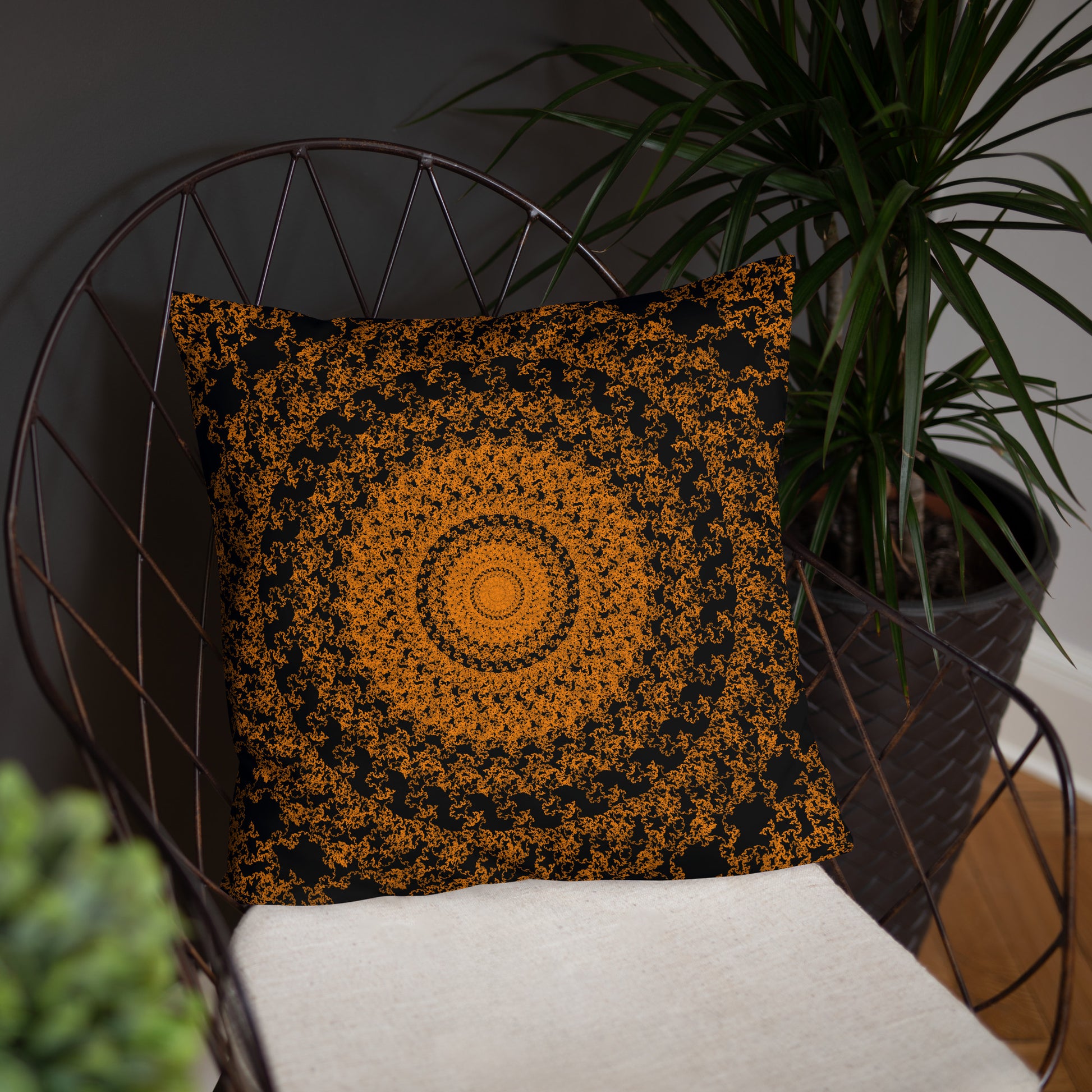 18″×18″ throw pillow with the 'The Sun' orange and black geometric design on a chair.