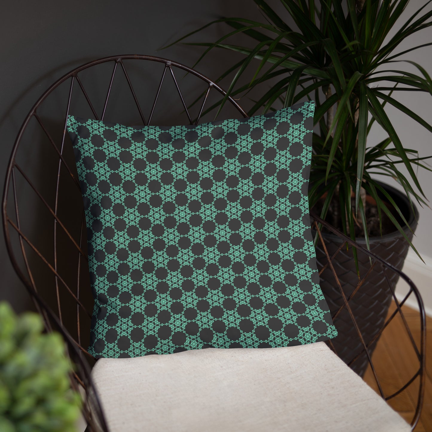 18″×18″ throw pillow with the 'Flowers Victory' charcoal and mint geometric pattern on a chair.
