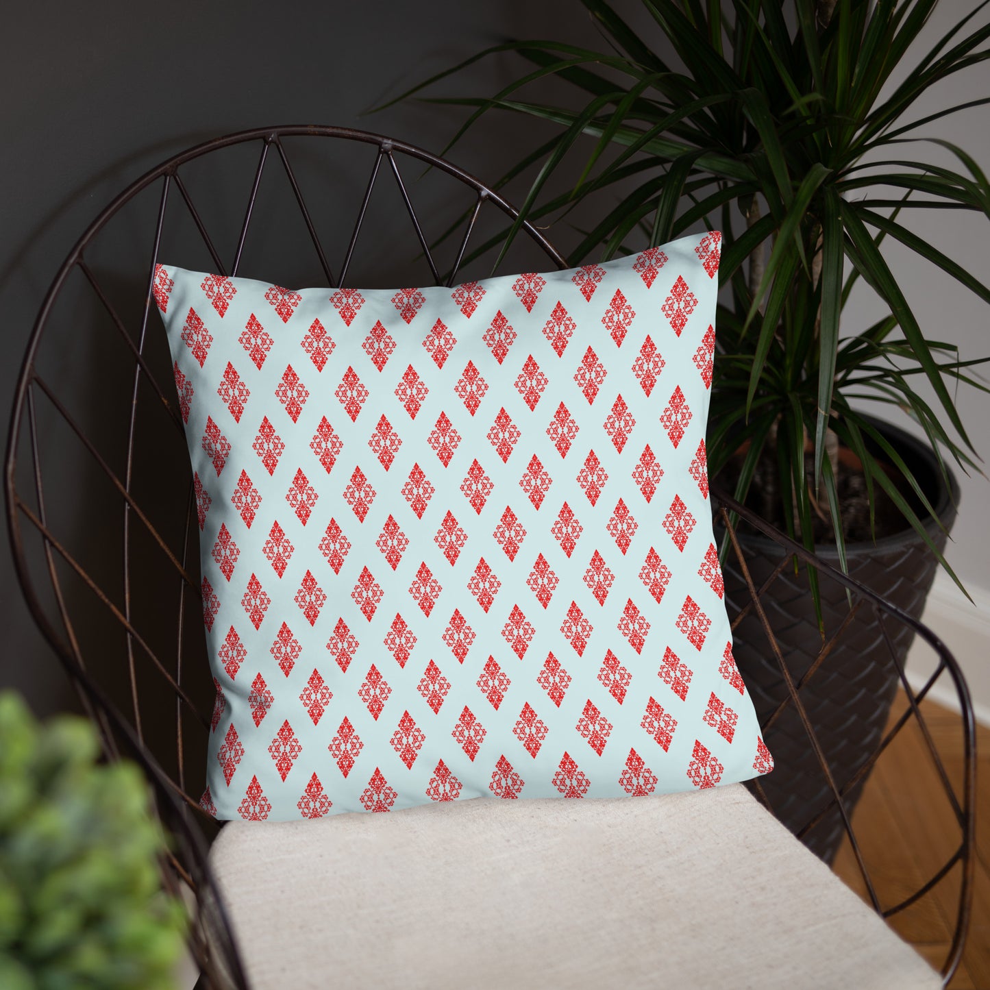 18″×18″ throw pillow with the 'Digon' sky blue and red geometric pattern on a chair.