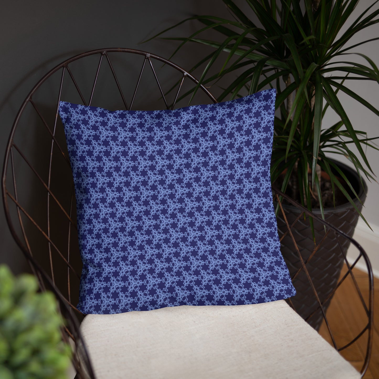 18″×18″ throw pillow with the 'Trigon' navy and blue geometric pattern on a chair.