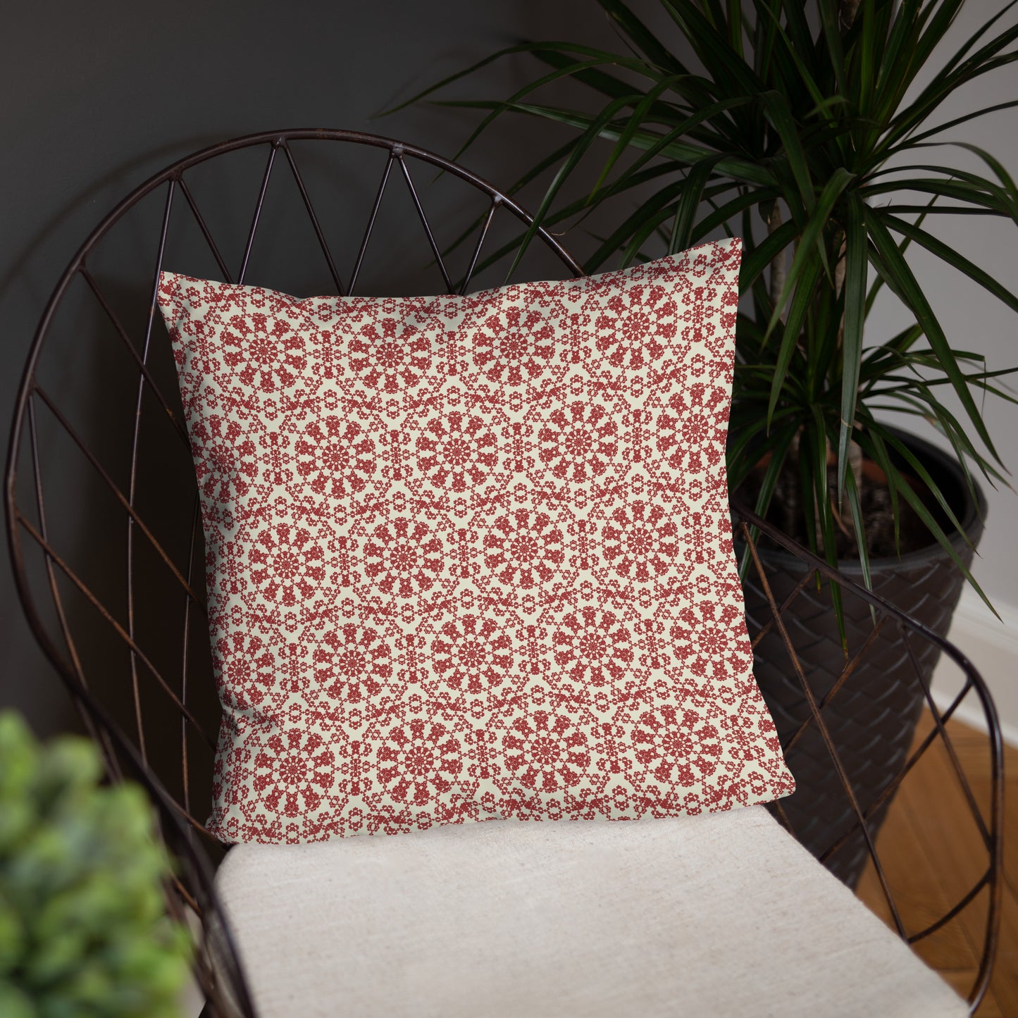 18″×18″ throw pillow with the ‘Decagon’ terracotta and beige geometric pattern on a wire chair against a dark background.
