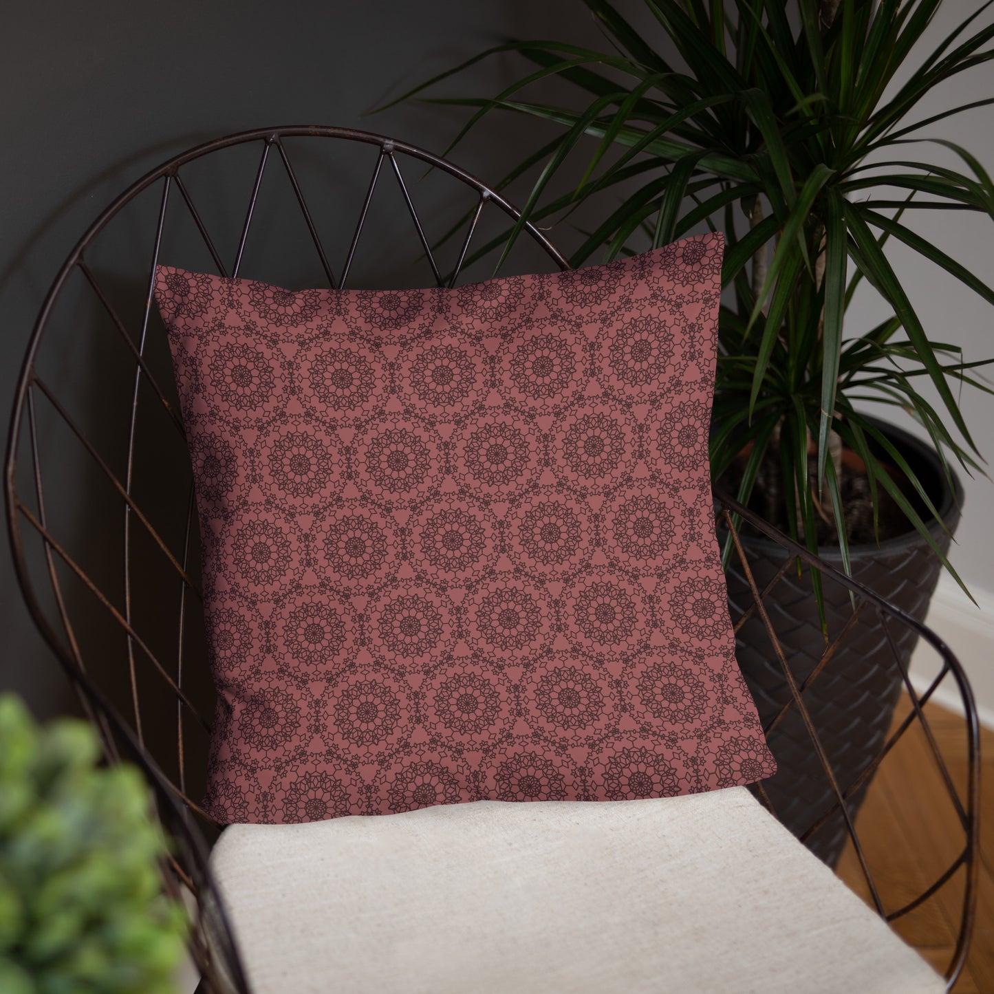 18″×18″ throw pillow with the 'Dodecagon' rose geometric pattern on wire chair with white cushion.