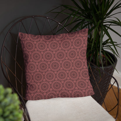 18″×18″ throw pillow with the 'Dodecagon' rose geometric pattern on wire chair with white cushion.