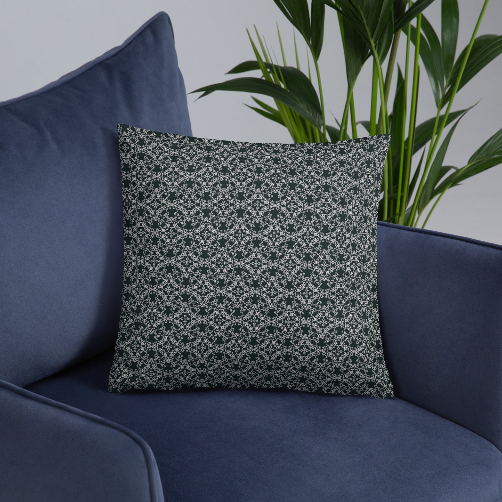 Front of the 18″×18″ basic pillow with the 'Quadragon' charcoal and white fractal geometric pattern on an armchair.