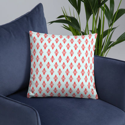 18″×18″ throw pillow with the 'Digon' sky blue and red geometric pattern on an armchair.