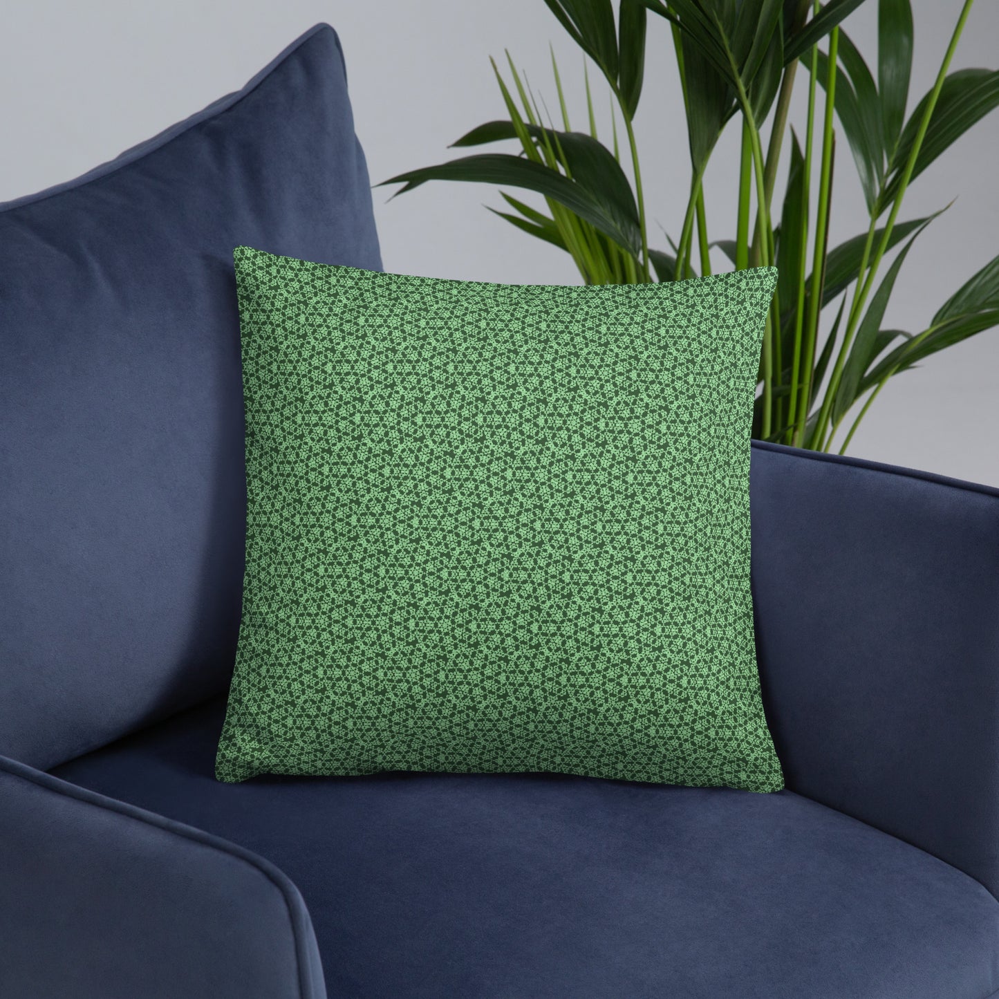 18″×18″ throw pillow with the 'Heptagon' green geometric pattern on an armchair.