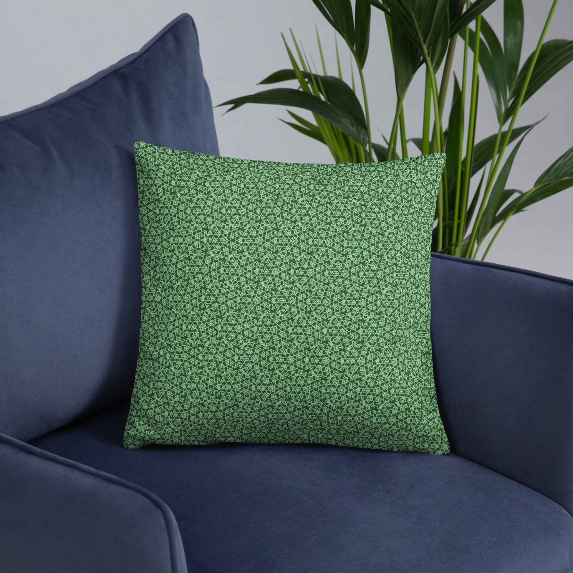18″×18″ throw pillow with the 'Heptagon' green geometric pattern on an armchair.