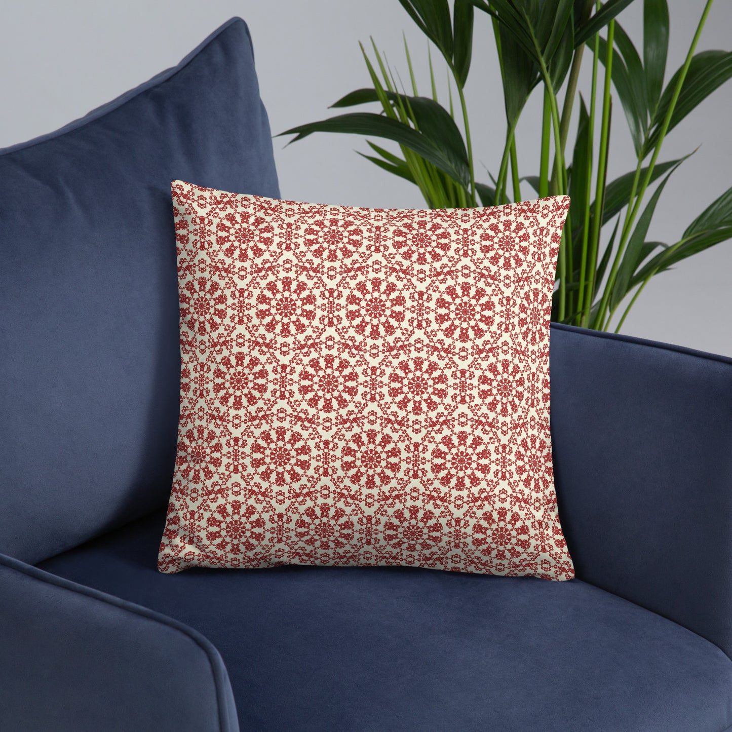 18″×18″ throw pillow with the ‘Decagon’ terracotta and beige geometric pattern on a navy blue armchair.